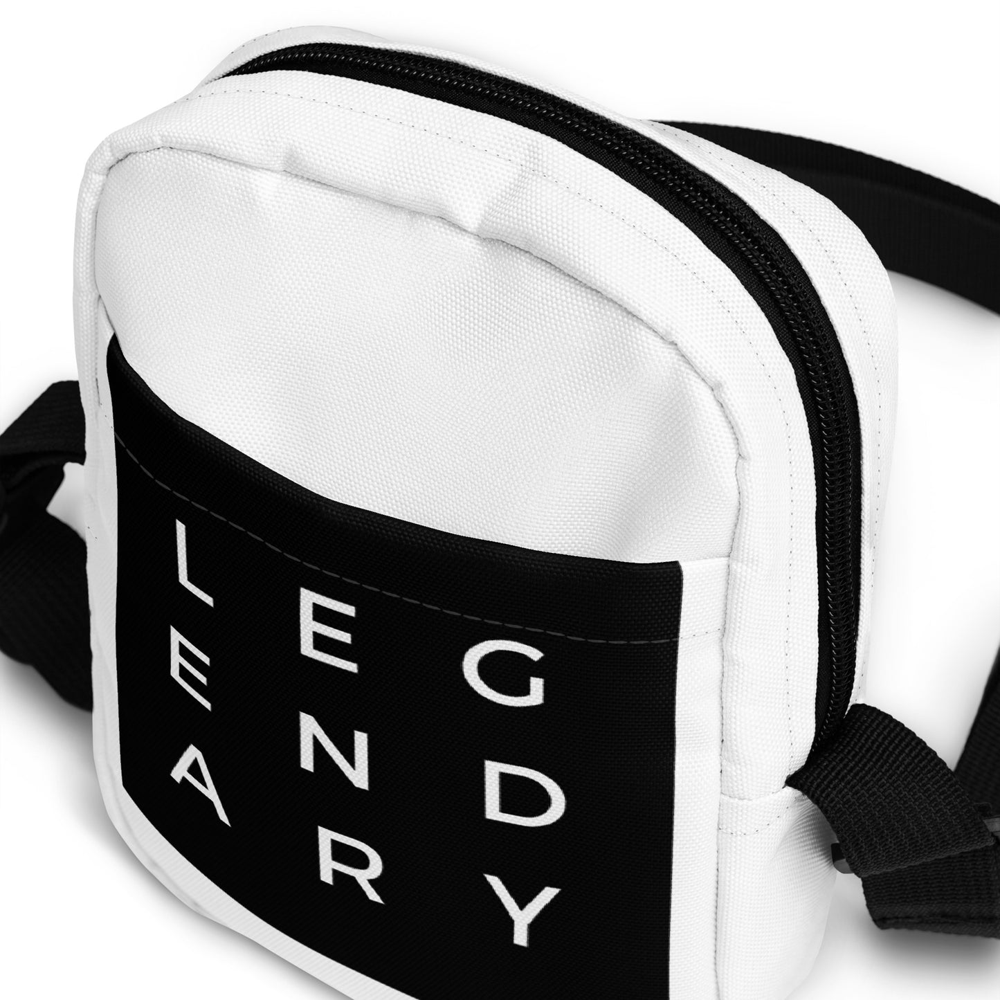 
                  
                    White crossbody bag with black logo panel, double-zip top, and stitched edges
                  
                